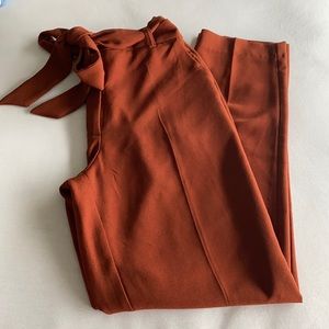 Burnt orange trousers with a tie belt and pockets.